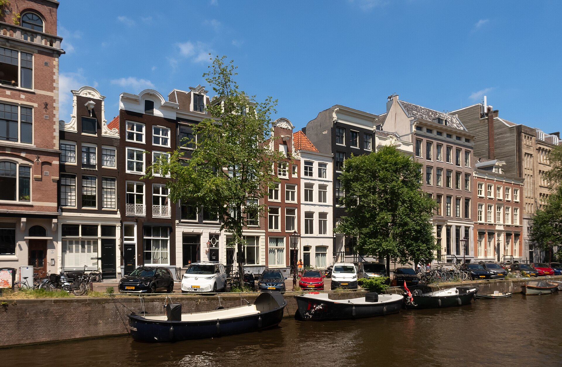 Casas de canal con frontones y barcos amarrados a lo largo del Herengracht en Ámsterdam