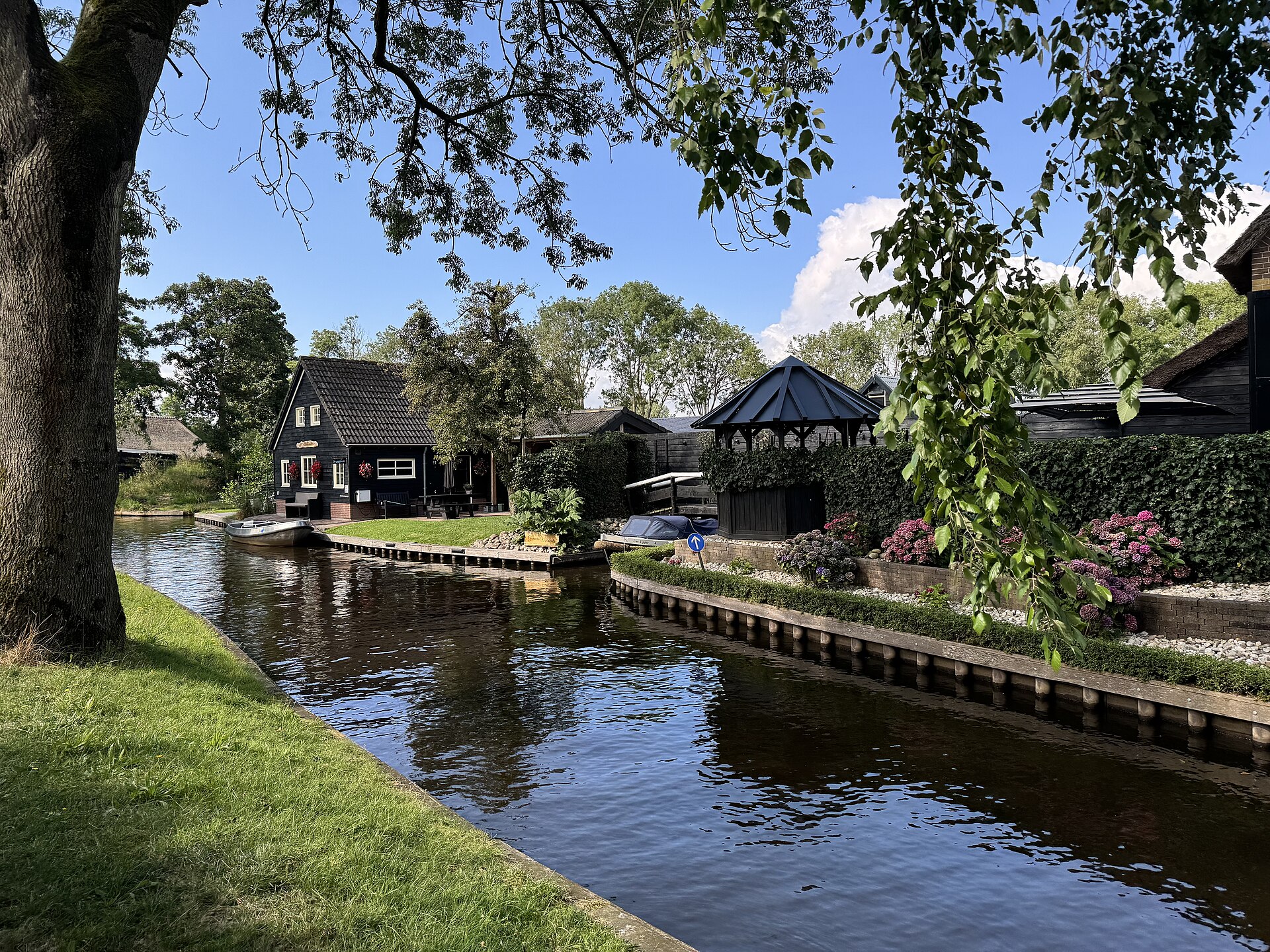 Árboles y un canal tranquilo bordeado de jardines en Giethoorn