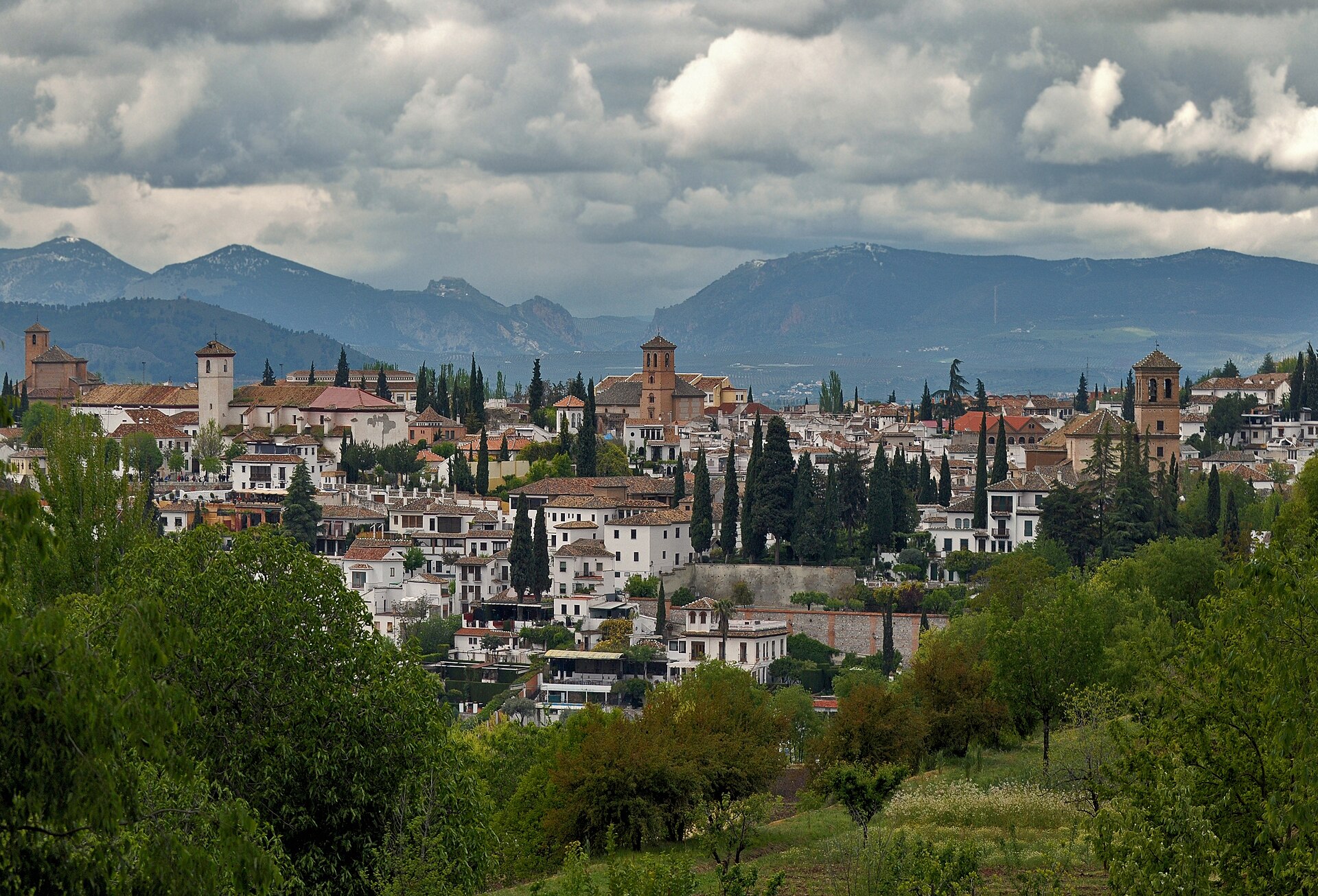 Las casas blancas del Albaicín de Granada vistas desde la Alhambra, con montañas al fondo
