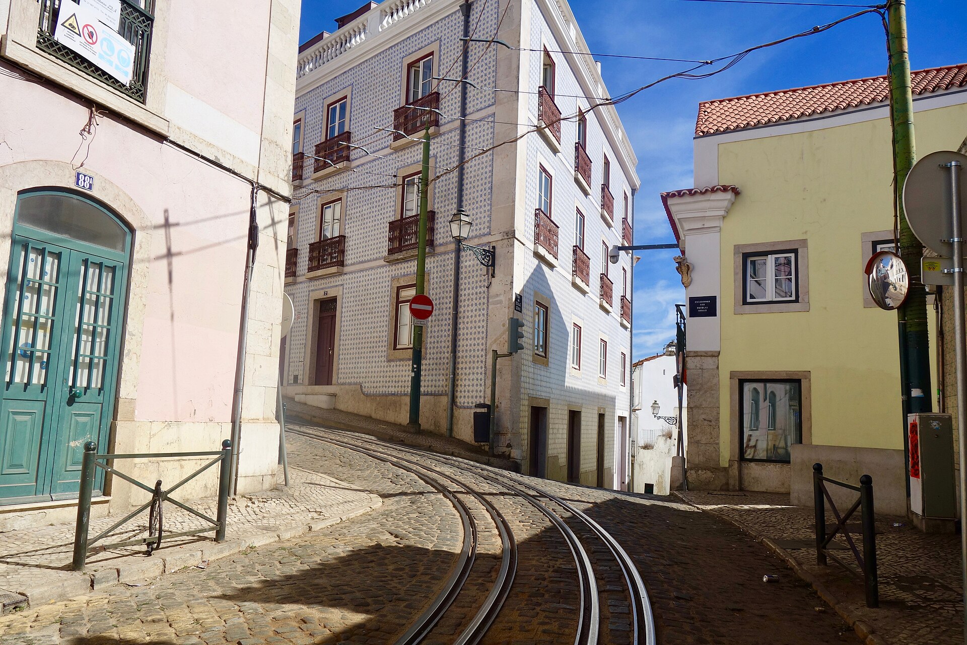 Vías de tranvía curvándose por una calle estrecha del barrio de Alfama en Lisboa