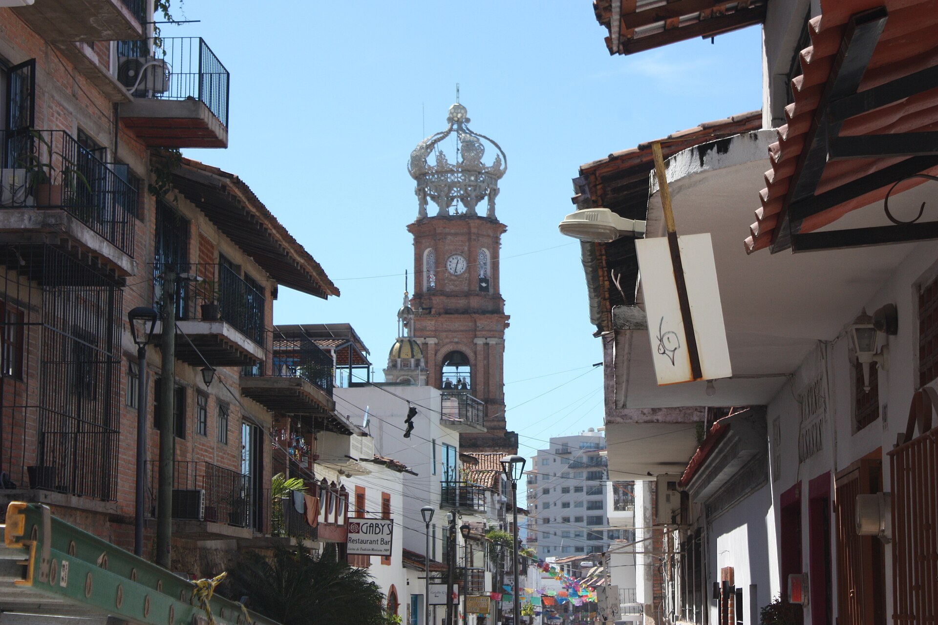 A cobbled street in Puerto Vallarta leading to the crowned tower of the Church of Our Lady of Guadalupe