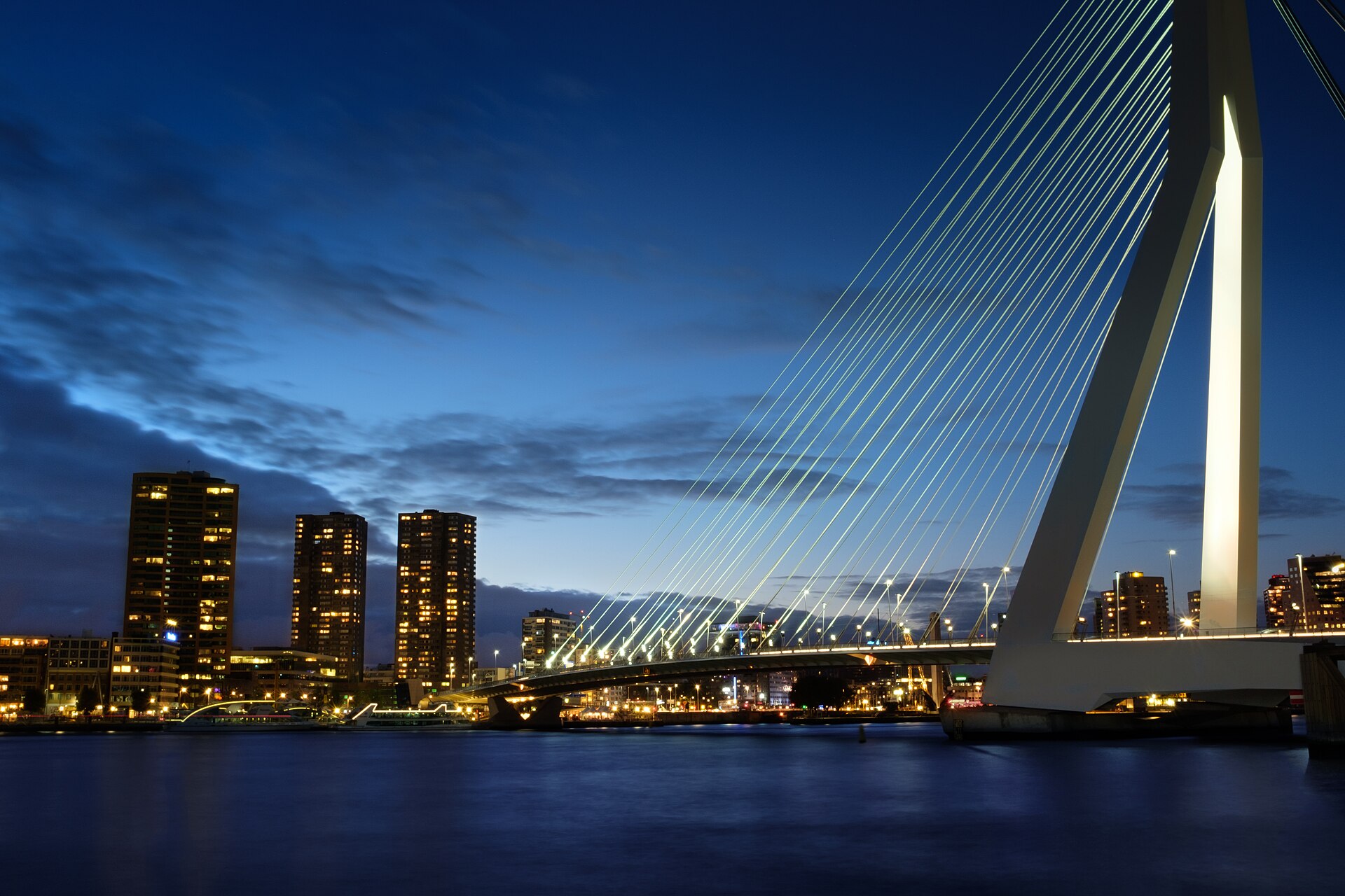El puente Erasmus y el perfil urbano de Róterdam sobre el río Mosa al anochecer