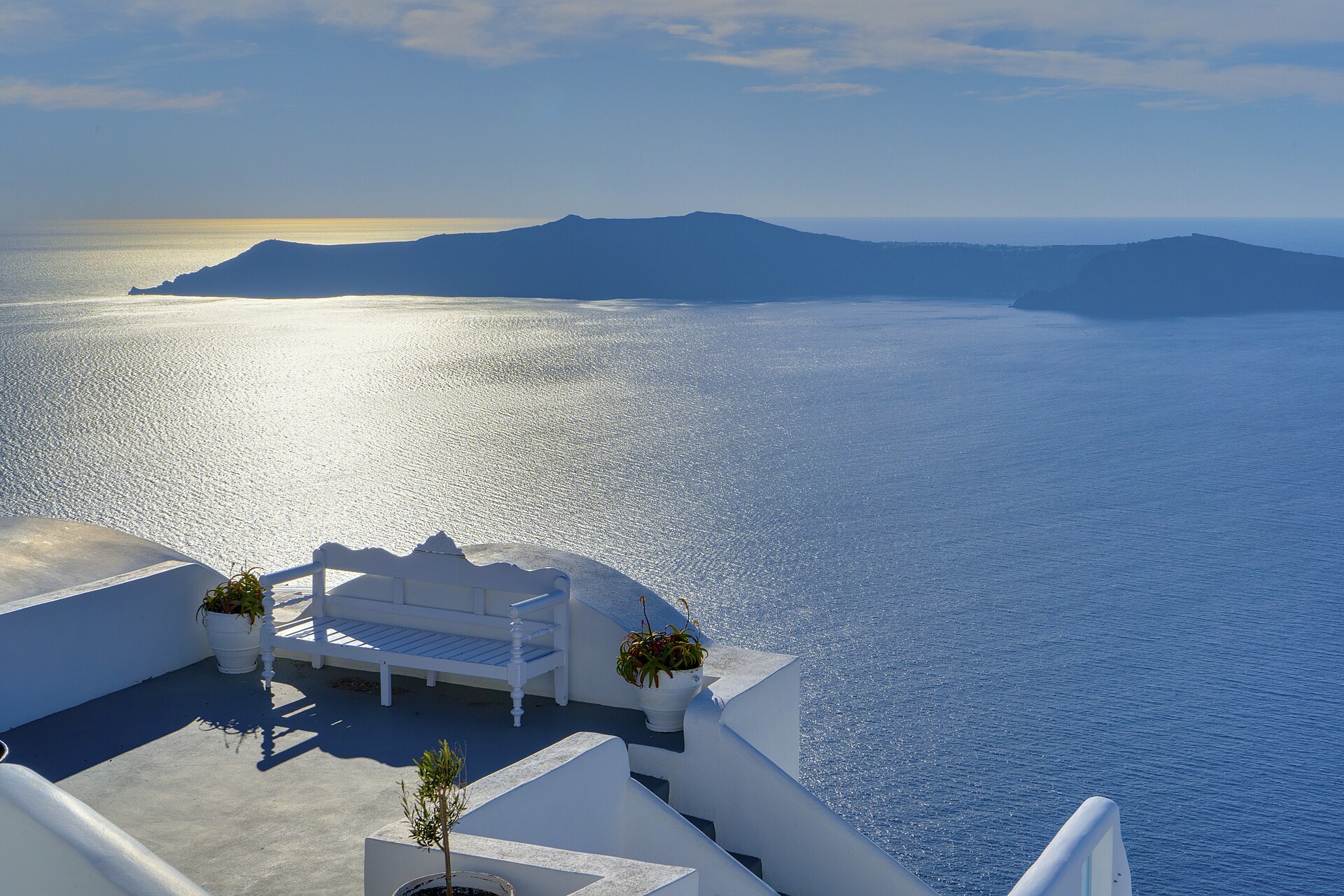 Una terraza blanca en Santorini con vista a la caldera y al mar