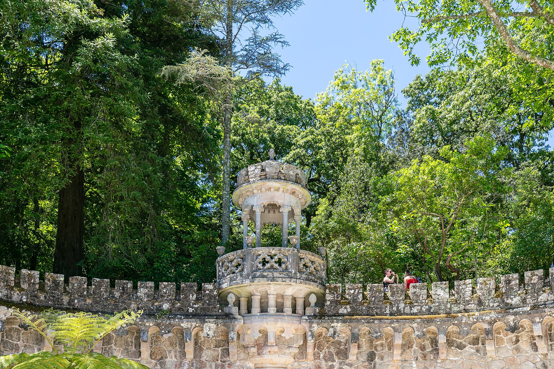Una torre con torreones entre los árboles de los jardines de la Quinta da Regaleira, en Sintra