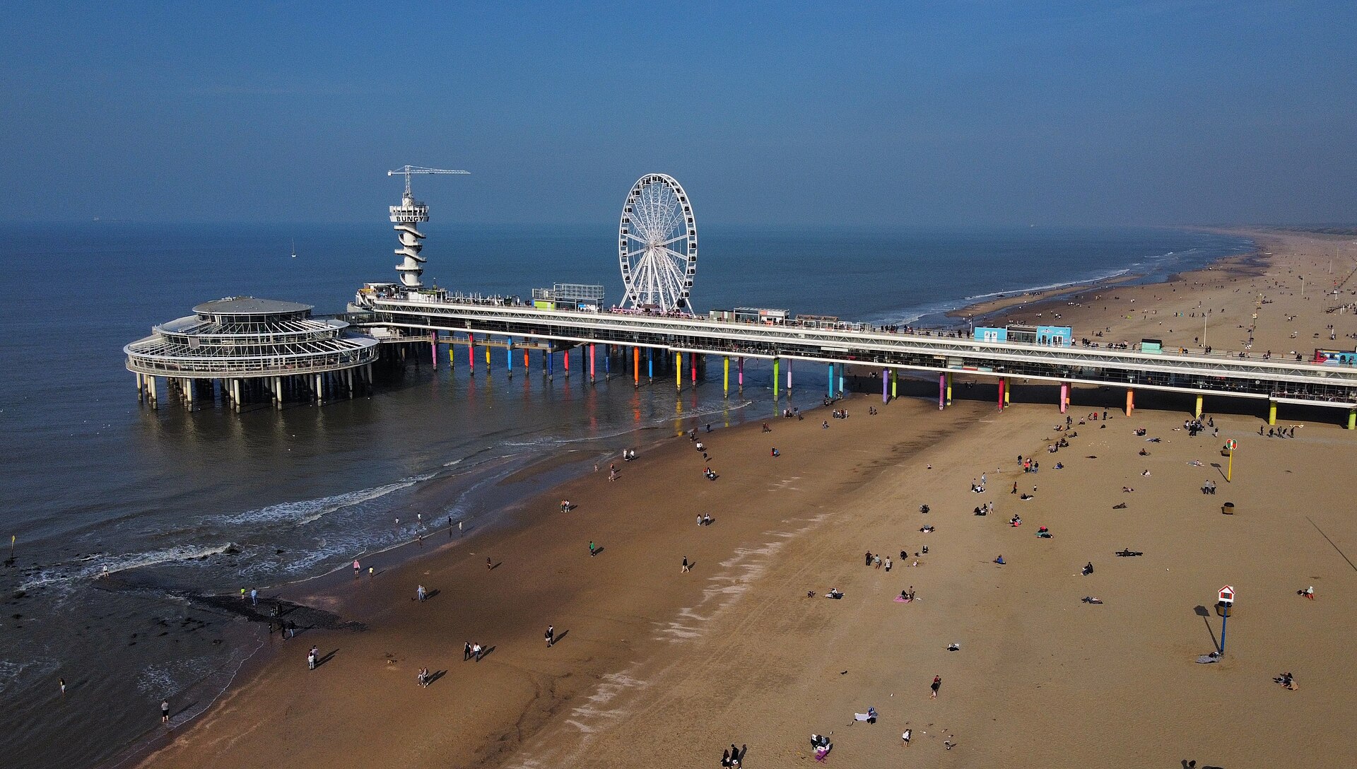 El muelle y la rueda de la fortuna de Scheveningen sobre la playa de arena