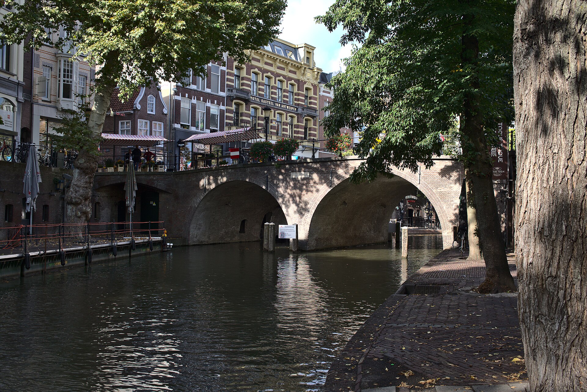 El muelle histórico a lo largo de un canal en Utrecht, con un puente y árboles